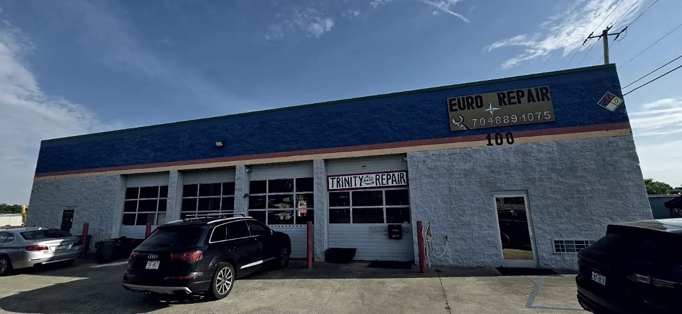 The shop at 100 College St: a blue-and-white building with a Euro Repair sign above and a Trinity Auto Repair sign on the bay door.